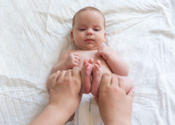 Una mamma che cambia il pannolino al neonato