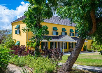 villa gialla immersa nel verde tropicale dell'isola Barbados