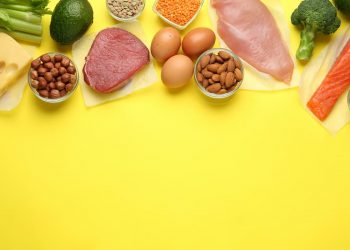 su sfondo giallo, alimenti ricchi di lisina con pesce, carne, uova e legumi