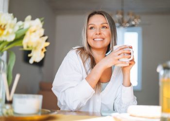 Una donna che beve una tisana come rimedio naturale per la ritenzione idrica