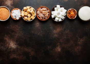 Su sfondo nero, tipologie di zuccheri in ciotole piccole
