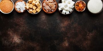 Su sfondo nero, tipologie di zuccheri in ciotole piccole