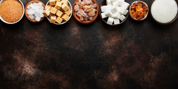 Su sfondo nero, tipologie di zuccheri in ciotole piccole