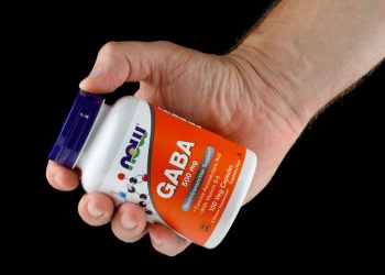 primo piano di una mano che impugna integratori di GABA
