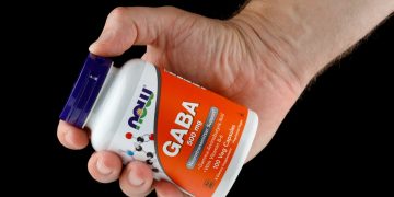 primo piano di una mano che impugna integratori di GABA