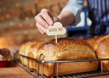 una forma di pane in cassetta con sopra un piccolo cartello con scritto gluten free (cibi senza glutine)