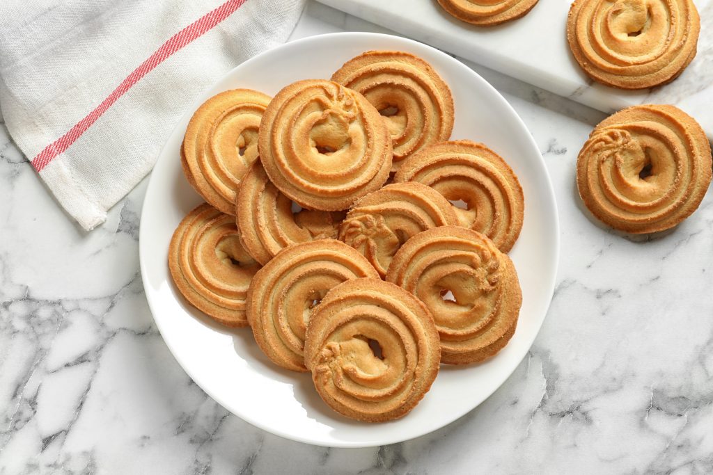 Frollini: la ricetta dei biscotti croccanti e gustosi 1 piatto bianco con biscotti frollini rotondi