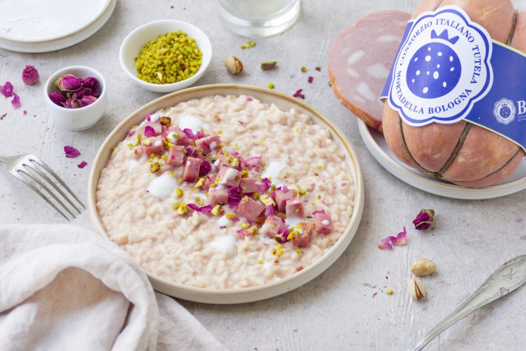 Risotto con mortadella posizionato su un tavolo con tovaglia bianca