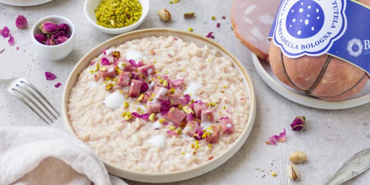Risotto con mortadella posizionato su un tavolo con tovaglia bianca