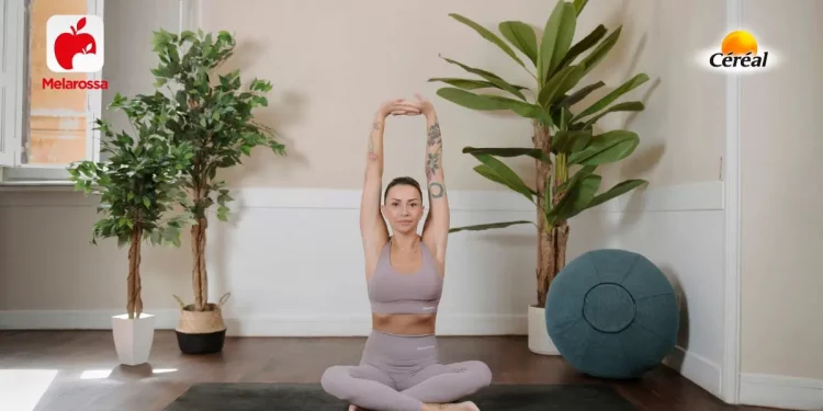 donna sul tappetino mentre esegue una posizione yoga, un pallone e tre piante