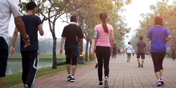 gruppo di persone che eseguono una camminata metabolica in un parco