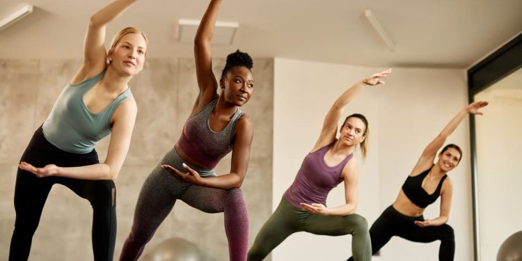 quattro donne che sono ad una lezione di pilates matwork e svolgono esercizi su un tappettino