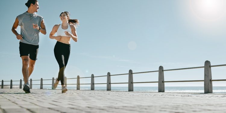 coppia che fa running sul lungomare e si guardano sorridendo