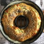 Ciambellone salato soffice con verdure e formaggio 1 su tavolo con tovaglia con foto di New York, tortiera con ciambellone salato