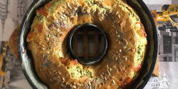 su tavolo con tovaglia con foto di New York, tortiera con ciambellone salato