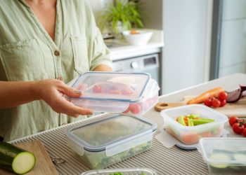 una donna che chiude dei contenitori alimentari per conservare il cibo