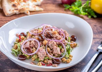 Insalata di ceci e tonno servita in un piatto fondo, con cipolla e olive taggiasche