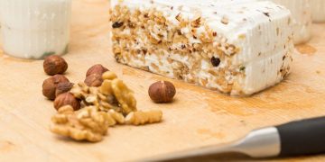 Presentazione della ricetta primosale con noci su un tagliere rustico