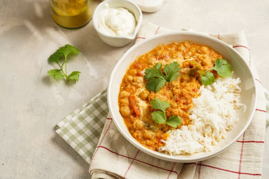 Dahl di lenticchie rosse: piatto unico speziato indiano 1 in primo piano su un piatto fondo bianco il dahl di lenticchie