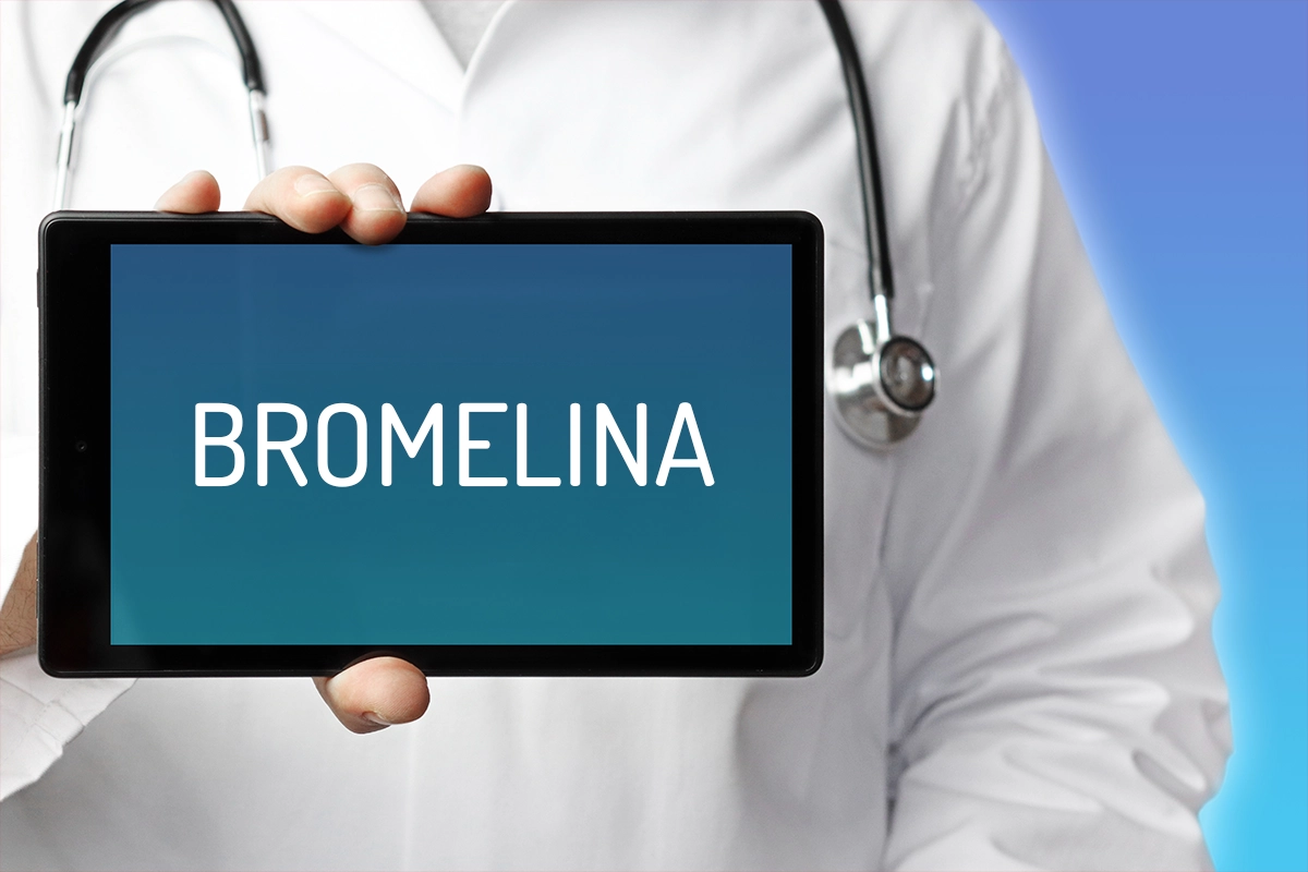 medico con camice bianco che tiene un ipad con scritta integratori di bromelina. Indossa un stetoscopio attorno al collo