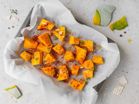 teglia rettangolare con carta forno con zucca a pezzetti
