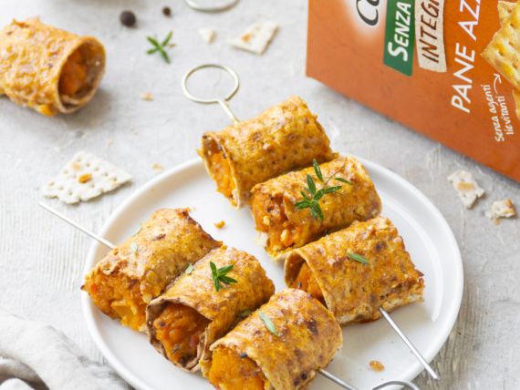 piatto bianco con sopra due spiedini di involtini di zucca
