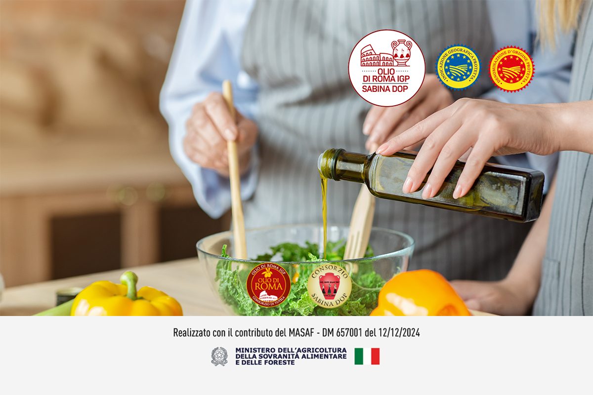 Su un tavolo da cucina una ciotola di insalata contornata da altri ingredienti. Viene condita da una donna con due mestoli di legno mentre un'altra donna versa con una bottiglia l'olio EVO. In alto il logo del progetto OLIO DI ROMA IGP E SABINA DOP e i loghi DOP e IGP, in basso i loghi del MASAF, dell'olio Sabina DOP e olio di Roma IGP.