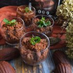 su base di legno 4 bicchierini di vetro pieni di crema al cioccolato