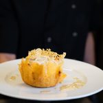 Cestini di Parmigiano per aperitivo e buffet: ricetta e video ricetta 1 chef che tiene in mano un piatto bianco e presenta dei cestini di parmigiano con ripieni di formaggio