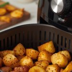 Patate con friggitrice ad aria: croccanti fuori e morbide dentro 1 cestello della friggitrice ad aria con dentro patate a pezzi dorati e croccanti