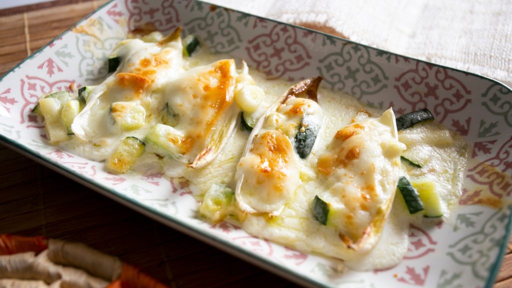  su tavolo piatto da forno  con indivia belga gratinata al forno con besciamella e zucchine
