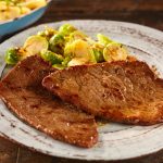 due paillard di vitello in un piatto accanto ai cavoletti di Bruxelles