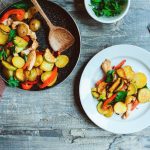 Pollo e zucchine al forno: ricetta leggera e saporita 1 su tavolo di legno padella con pollo e zucchine e altre verdure come patate peperoni