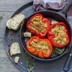Peperoni ripieni di tonno: la ricetta al forno facile e gustosa 1 Peperoni rossi e gialli ripieni di tonno e ricotta, serviti in una padella nera con fette di pane, timo fresco e tovagliolo a quadri sullo sfondo.