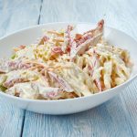 Insalata capricciosa: ricetta facile e cremosa 1 su base di legno celeste un piatto fondo bianco con insalata capricciosa