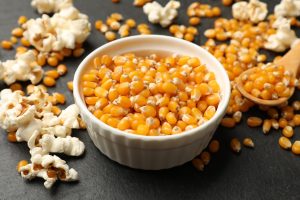 Iscriviti subito alla dieta Melarossa e scarica l'app 15 su tavolo ciotola bianca con chicchi di mais e attorno pop corn