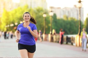 Home Page 67 al parco una giovane donna ha iniziato a correre per dimagrire. E' vestita con una maglietta azzurra e uno short nero ed è molto sorridente !