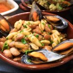 Pasta fagioli e cozze: la ricetta napoletana facile e saporita 1 In primo piano in una ciotola di terracotta c'รจ la pasta fagioli e cozze con prezzemolo fresco.